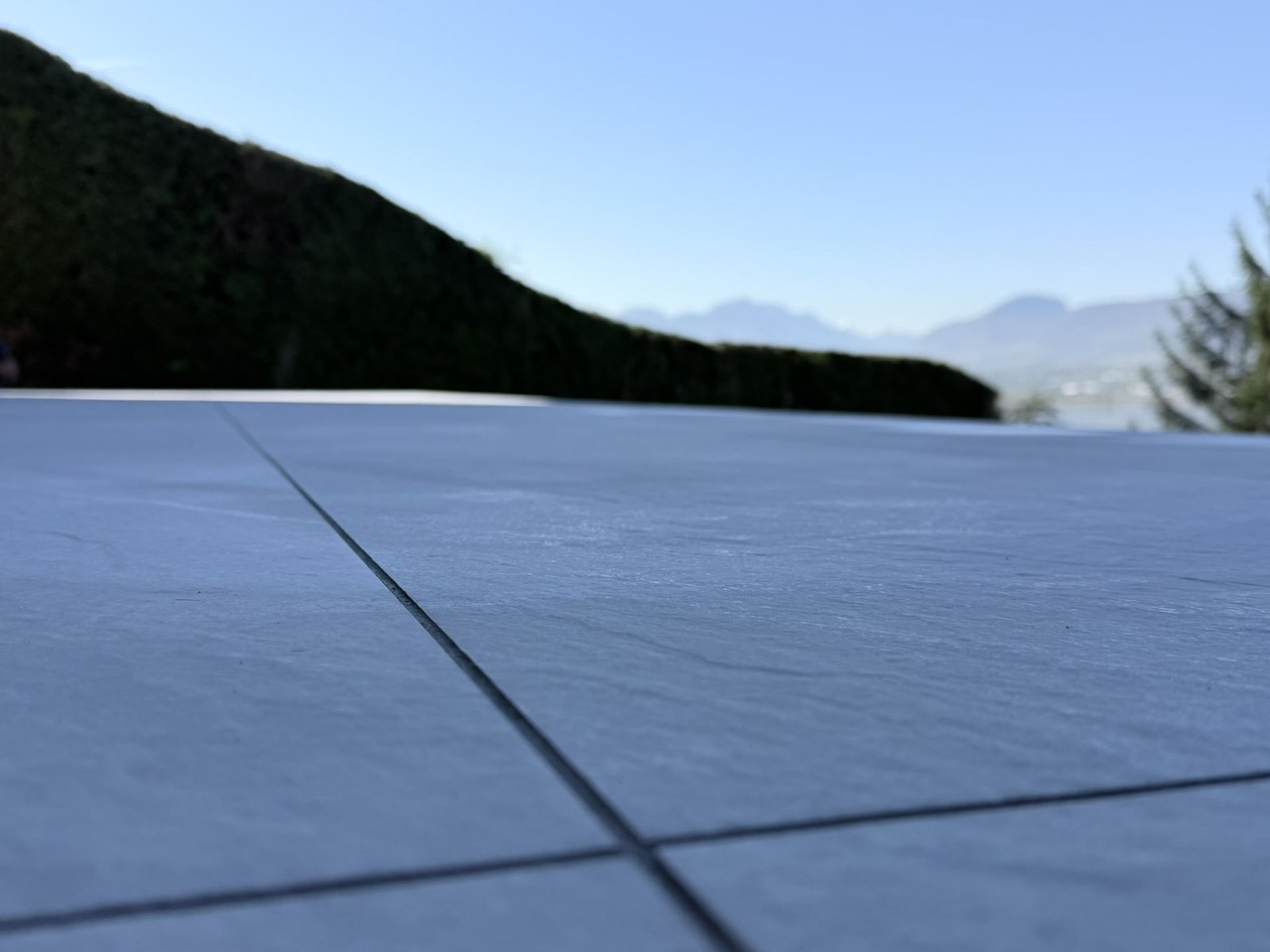 Detail joint carrelage gris terrasse vue montagnes Savoie Kocak
