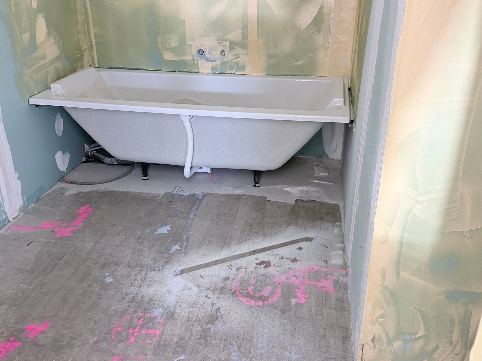 Salle de bain avant rénovation baignoire et sol brut Chambéry