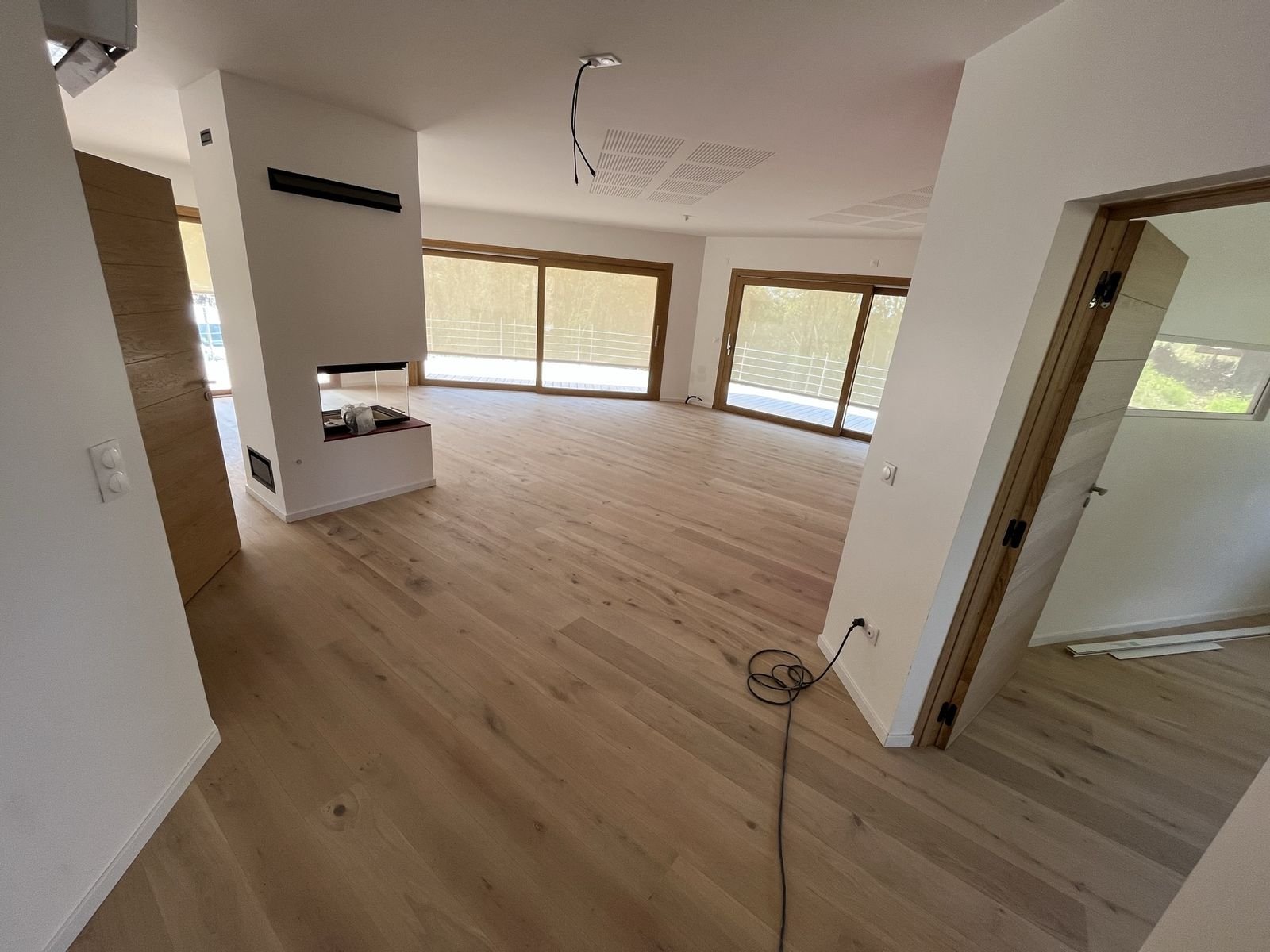 Pose parquet chêne clair dans un salon avec cheminée en Savoie