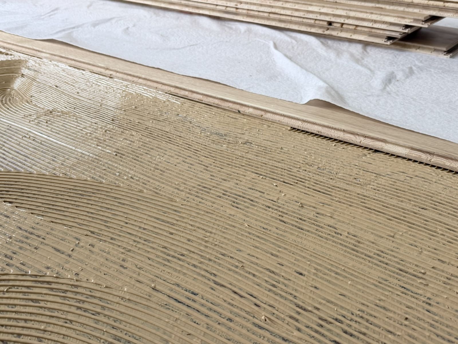 Pose parquet collée, encollage du sol par l'artisan en Savoie